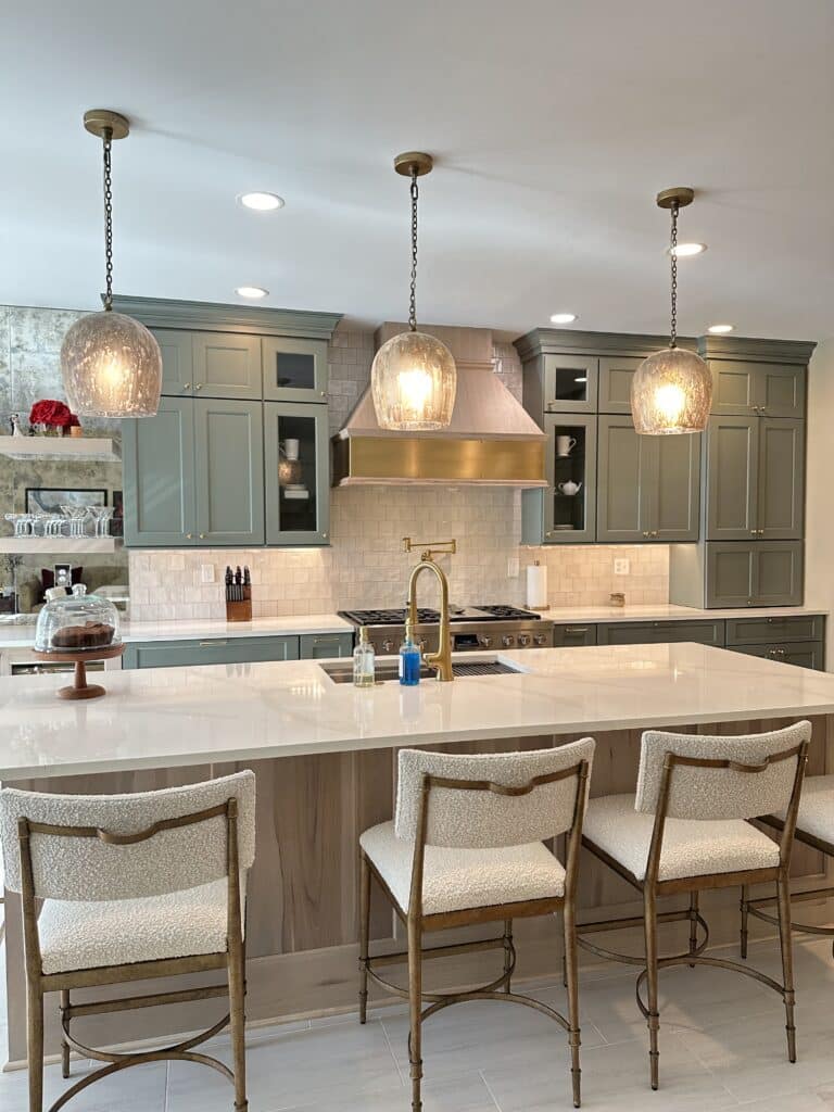 Custom kitchen with Brighton cabinetry, Viatera quartz countertops, and a large island with three pendant lights overhead