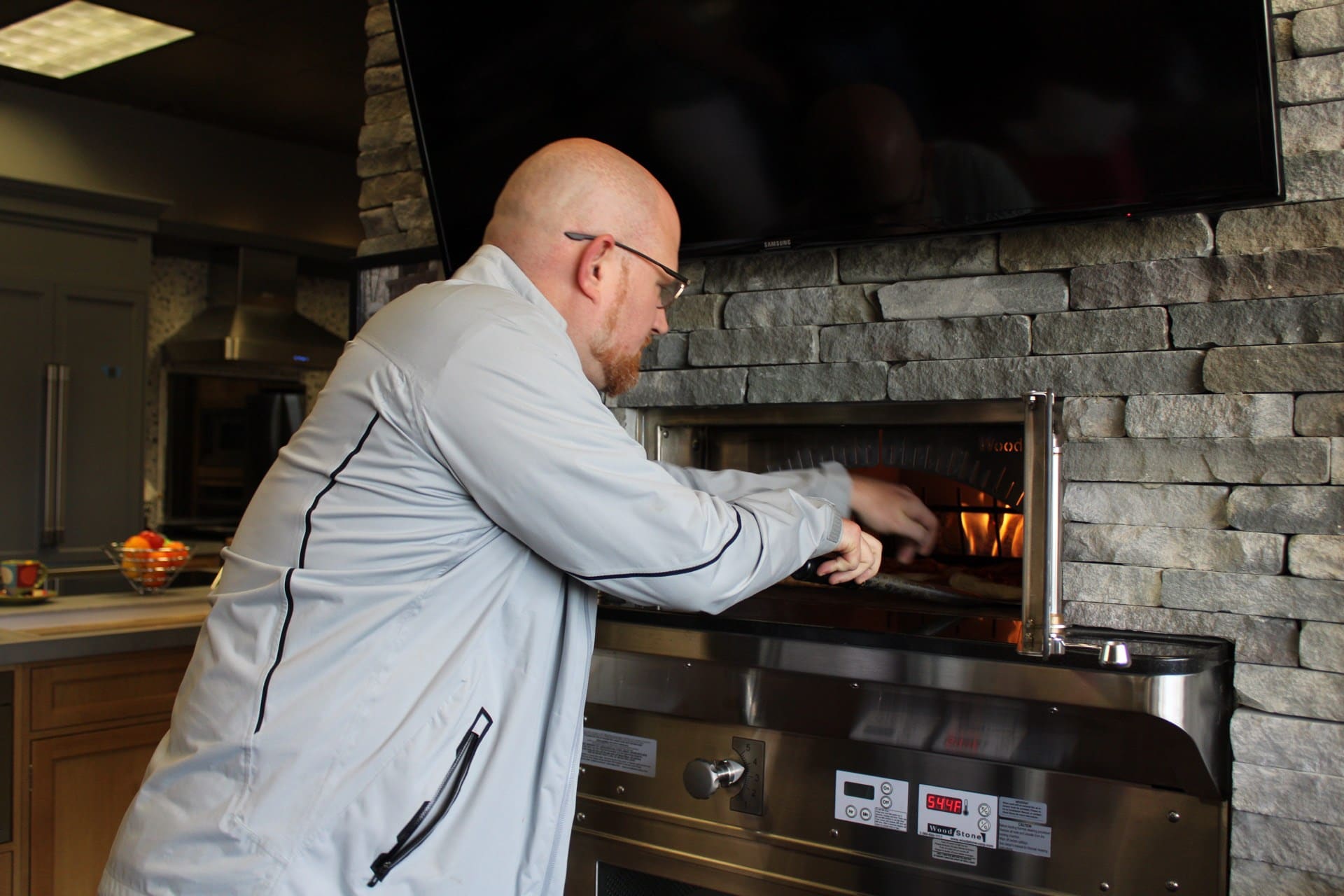 Man putting pizza in oven