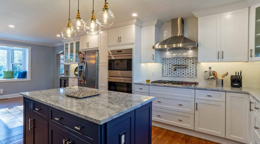 Kitchen in Bryn Mawr, PA with white cabinetry and a blue island with gray countertop