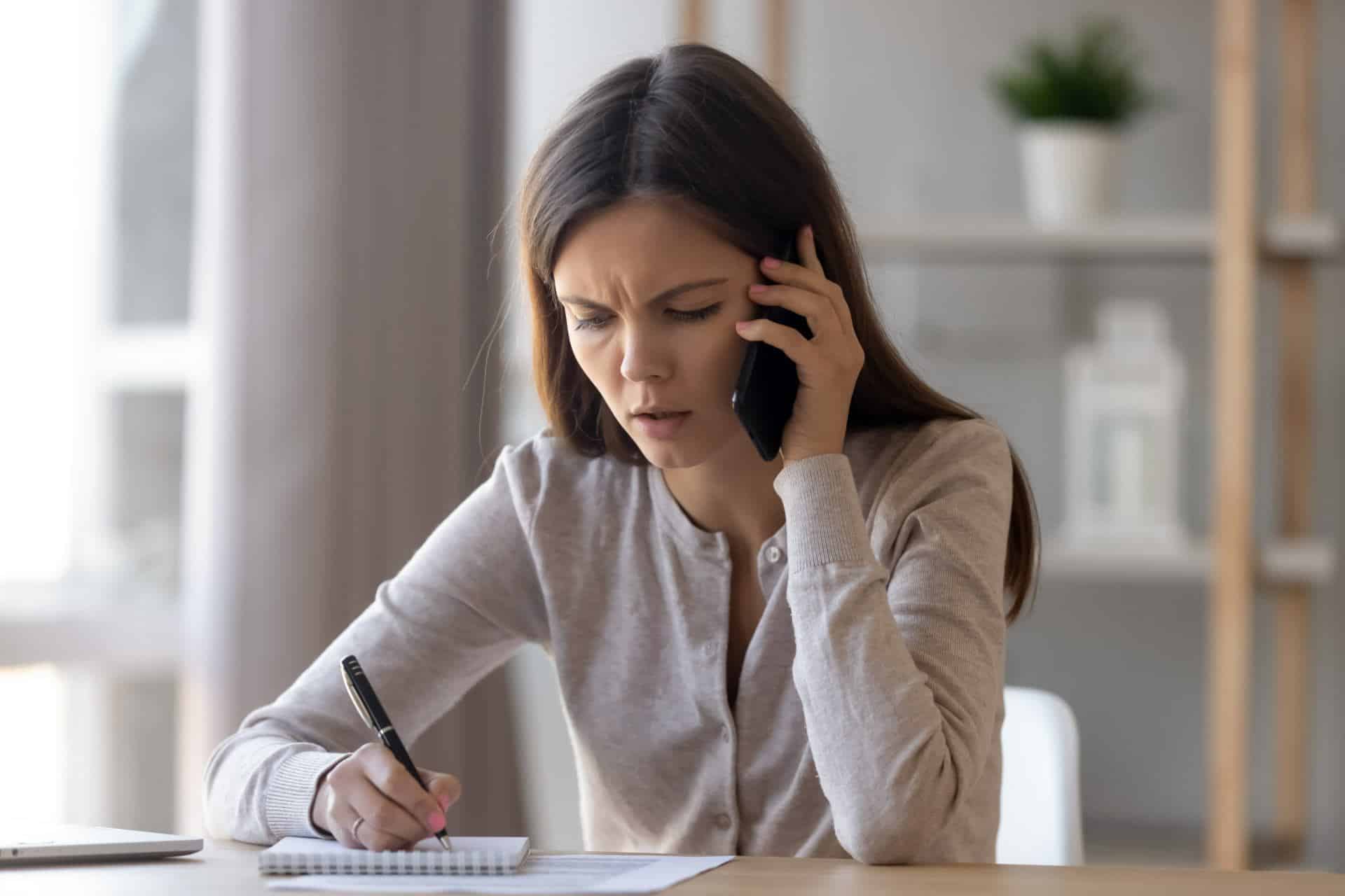 woman taking notes looking confused